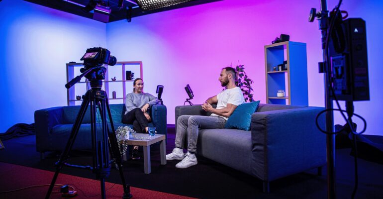 “Two hosts recording a podcast interview in Fluent Media’s Bromley video-podcast studio”